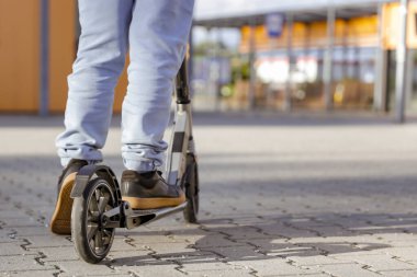 Motosikletli çocuk, Skooter 'da Legs in Leans in Skooter' ın yakın çekiminde. Aktif yaşam tarzı ve gençlik kültürü, şehir sporları, özgürlük ve boş zamanı sağlıklı ve eğlenceli bir şekilde geçirmek.. 