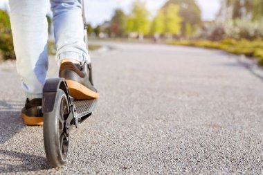 Motosikletli çocuk, Skooter 'da Legs in Leans in Skooter' ın yakın çekiminde. Aktif yaşam tarzı ve gençlik kültürü, şehir sporları, özgürlük ve boş zamanı sağlıklı ve eğlenceli bir şekilde geçirmek.. 