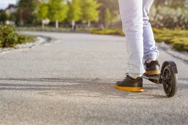 Motosikletli çocuk, Skooter 'da Legs in Leans in Skooter' ın yakın çekiminde. Aktif yaşam tarzı ve gençlik kültürü, şehir sporları, özgürlük ve boş zamanı sağlıklı ve eğlenceli bir şekilde geçirmek.. 