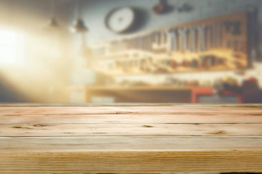 Bir marangoz atölyesinin bulanık arka planının önündeki ahşap masa. El yapımı ürünleri, araçları veya DIY içeriğini tanıtmak için harika