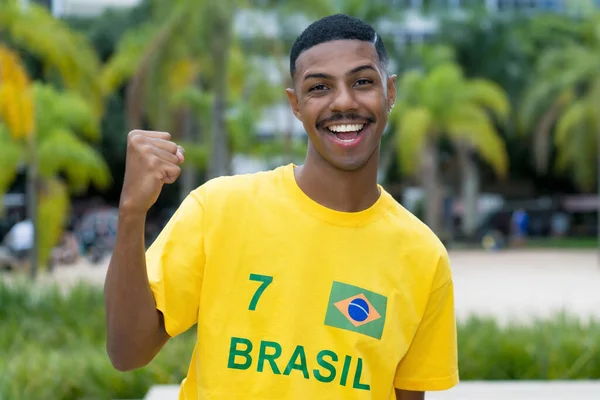在圣保罗 来自巴西的快乐年轻人穿着黄色足球球衣站在户外 — 图库照片