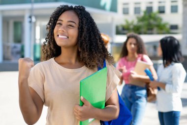 Şehirde başarılı bir siyahi kız öğrenci ve bir grup Latin Amerikalı ve beyaz yetişkin.