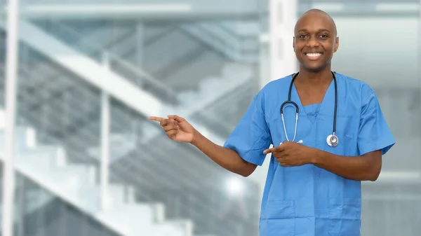 Black doctor or male nurse pointing sideways at hospital