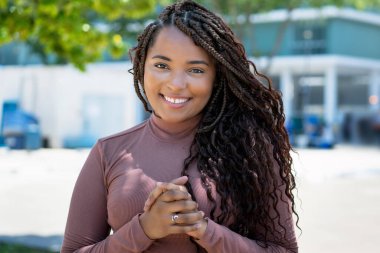 Laughing african american woman with braid outdoor in summer in city