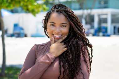 Beautiful african american woman with braid outdoor in summer in city