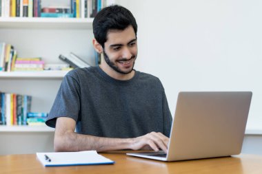 Laughing israeli IT specialist at work at computer at desk at computer