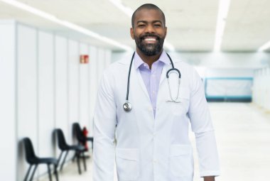 Hastanede sakallı, olgun, pozitif siyah bir doktor.