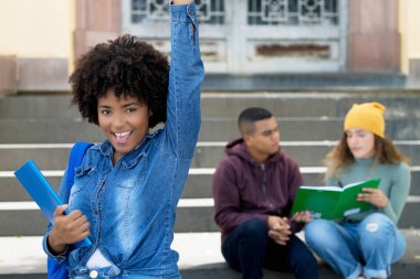 Bir grup İspanyol genç yetişkinin şehir tarzında başarılı tezahüratları Afrikalı Amerikalı kız öğrenci