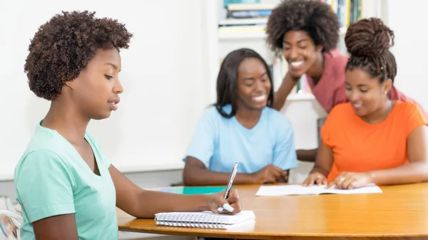 Praca Czarna Studentka Przy Biurku Grupą Uczących Się Afrykańskich Amerykańskich — Zdjęcie stockowe