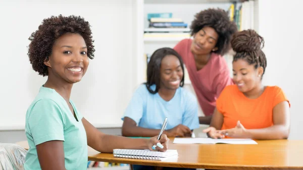 책상에서 여학생을 웃으며 교실에서 아프리카 미국인 학생들을 배우는 — 스톡 사진