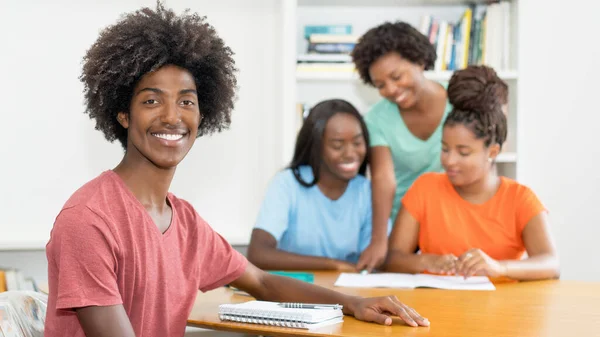 Śmiejący Się Czarny Mężczyzna Student Przy Biurku Grupą Uczących Się — Zdjęcie stockowe