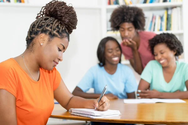Czarna Studentka Recepcji Pisząca Test Grupą Uczących Się Afrykańskich Amerykańskich — Zdjęcie stockowe