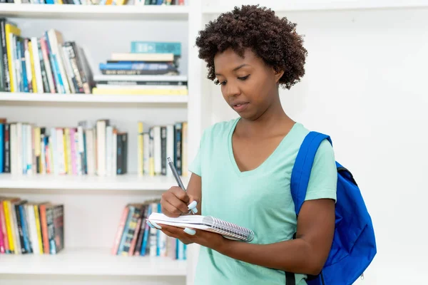 Estudiante Afroamericana Ambiciosa Con Mochila Escribiendo Notas Biblioteca Universidad — Foto de Stock
