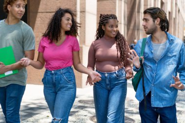 Bir grup İspanyol ve Afrikalı Amerikalı öğrenci yazın açık havada tartışıyorlar.