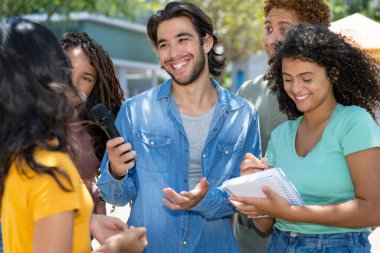 Şehirdeki açık hava röportajında bir grup gazeteciyle İspanyol erkek gazeteci