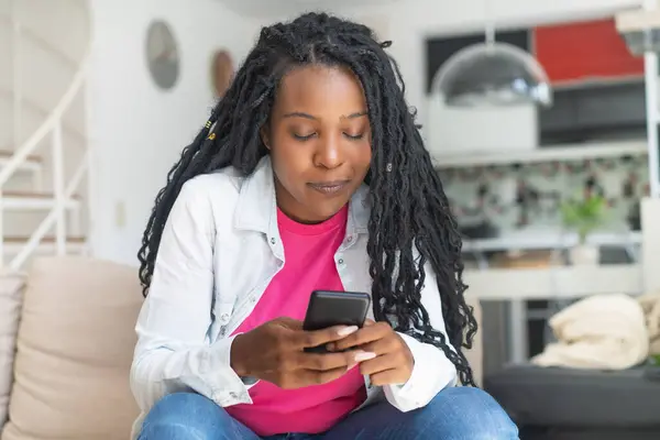 Vážná Afro Americká Žena Dredy Posílat Psaní Telefonu Doma Obývacím — Stock fotografie
