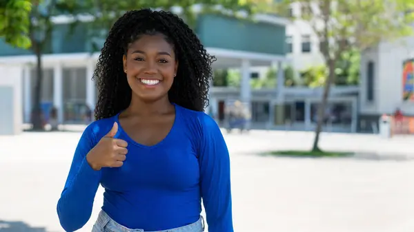 Ganska Afrikansk Amerikansk Ung Vuxen Kvinna Visar Tummen Upp Med Royaltyfria Stockbilder