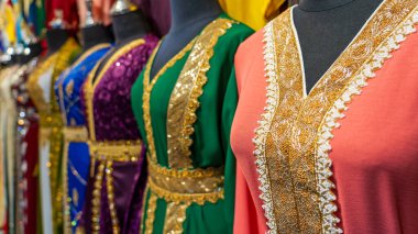 Doha, Katar - 10 Ocak 2023: Arap kadınlar, Souq Faleh 'deki bir tekstil dükkanında koftan giyiyorlar..