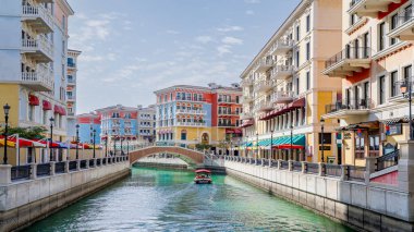 Qanat Quartier, Doha, Katar - 20 Şubat 2024: Venedik konseptli inci yerleşim bölgesinde canlı renkli konut ve dükkanlar.