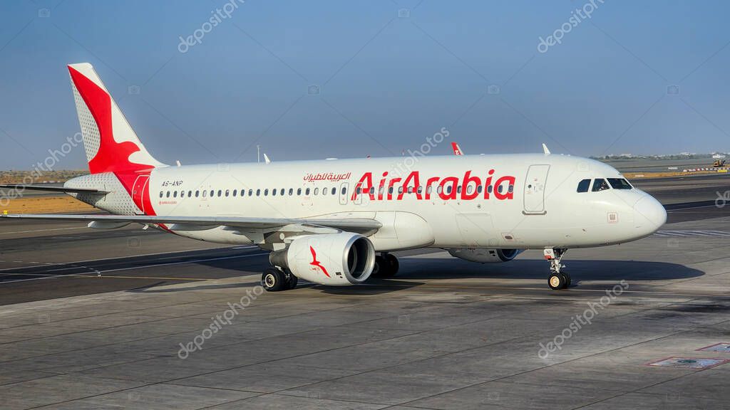 Doha, Qatar October 12, 2024: Air Arabia flight at Sharjah Airport, UAE, showcasing the aircraft on the tarmac with passengers boarding and the airline's signature red and white livery visible.