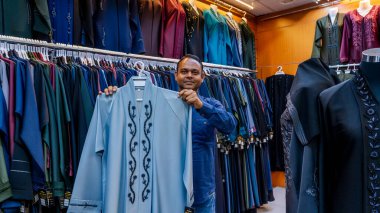 Doha, Katar, 18 Ekim 2024: Geleneksel Arap abayaları ve giysileri Souq Waqif 'teki bir kumaş mağazasında satılığa çıkarıldı..