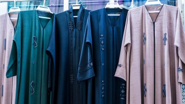 Doha, Katar, 18 Ekim 2024: Geleneksel Arap abayaları ve giysileri Souq Waqif 'teki bir kumaş mağazasında satılığa çıkarıldı..