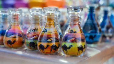Doha, Katar, 24 Ocak 2025: Canlı kum tabakalarıyla dolu bir cam şişe karmaşık desenler oluşturuyor, sanatsal hassasiyet ve kültür mirası sergiliyor.