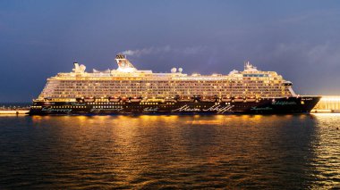 Doha, Katar-Ocak 2025: Mein Schiff 6, limana yanaşan görkemli bir yolcu gemisi, çarpıcı deniz manzarasına karşı modern tasarımı ve lüks tesislerini sergiliyor..