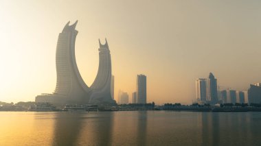 Doha, Katar 24 Şubat 2025: Sis içinde kısmen gizlenmiş gökdelenlerle Doha 'da sisli bir sabah, gizemli ve sakin bir şehir manzarası yaratıyor..