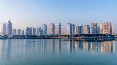 Doha, Katar - 24 Şubat 2025: Sis içinde kısmen gizlenmiş gökdelenlerle Doha 'da sisli bir sabah, gizemli ve sakin bir şehir manzarası yaratıyor..