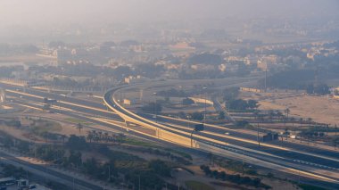 Lusail, Katar - 24 Şubat 2025: Lusail 'de sisle kaplı bir otoyol, düşük görüş mesafesi ve parıldayan sokak lambalarıyla gizemli bir atmosfer yaratıyor..