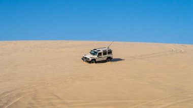 Sealine, Katar - 24 Şubat 2025: Uçsuz bucaksız gökyüzü altında heyecan verici bir çöl macerası yaratan off-road araçları altın kum tepeleri üzerinde yarışıyor