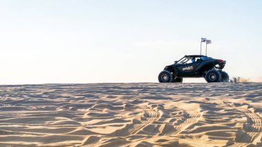 Sealine, Katar - 24 Şubat 2025: Uçsuz bucaksız gökyüzü altında heyecan verici bir çöl macerası yaratan off-road araçları altın kum tepeleri üzerinde yarışıyor