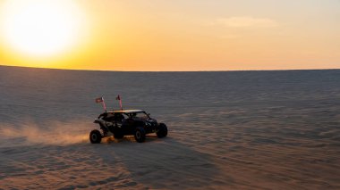Sealine, Katar - 24 Şubat 2025: Uçsuz bucaksız gökyüzü altında heyecan verici bir çöl macerası yaratan off-road araçları altın kum tepeleri üzerinde yarışıyor