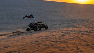 Sealine, Katar - 24 Şubat 2025: Uçsuz bucaksız gökyüzü altında heyecan verici bir çöl macerası yaratan off-road araçları altın kum tepeleri üzerinde yarışıyor