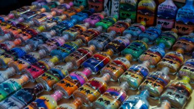 Doha, Katar, 24 Ocak 2025: Canlı kum tabakalarıyla dolu bir cam şişe karmaşık desenler oluşturuyor, sanatsal hassasiyet ve kültür mirası sergiliyor.