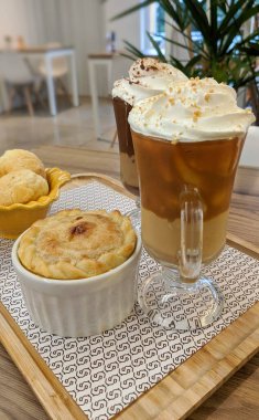 Beyaz kare tabakta çikolatalı waffle ve arka planda karamel kaplı waffle. 