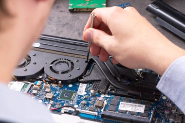 Bilgisayarın anakart veya dizüstü bilgisayarını tamir eden eller hizmete hazır olsun. Laptop tamir servisi. Bilgisayar donanım güncellemesi ve bakımı. Mühendis bozuk defteri tamir ediyor.