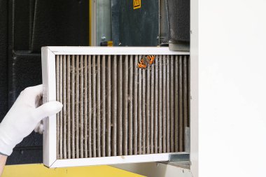 hvac filtresi değiştiriliyor. Merkezi havalandırma sistemindeki filtreyi değiştiriyorum, fırın. Ev merkezi klima sistemi için Kirli Hava filtresi değiştiriliyor. Döner ısı değiştiricideki filtreyi değiştir