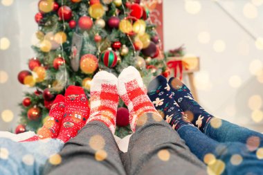Yılbaşı çorapları içinde insan ayağı Noel ağacının arka planında. Yılbaşı çorapları kapanır. Noel sade arka planı