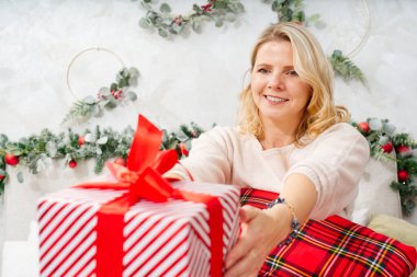 Noel, yeni yıl, tatil konsepti. Mutlu Kadın Noel hediyesi olarak hediye kutusu alıyor. Sana bir sürprizim var. Heyecanlı bir kadın beklenmedik bir Noel süsü alıyor..