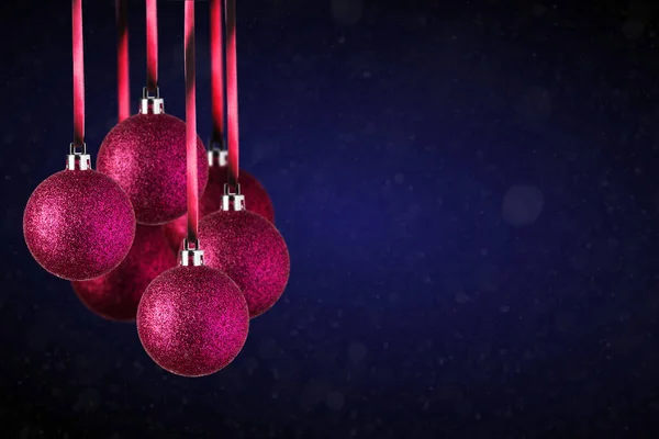 红色圣诞树饰物挂在复制空间 圣诞玻璃球或塑料球悬挂在抽象的深蓝色背景之上 — 图库照片
