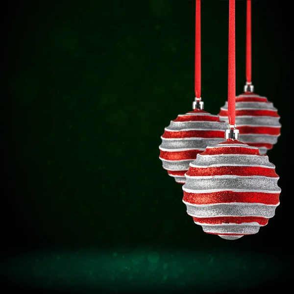 红色圣诞树饰物挂在复制空间 圣诞玻璃球或塑料球悬挂在抽象的深绿色背景之上 — 图库照片