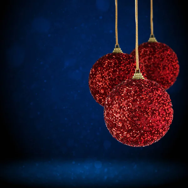 コピースペースにぶら下がっている赤いクリスマスツリーの装飾 ガラス製のクリスマスボールやプラスチック製の抽象的な濃い青の背景にぶら下がっている — ストック写真