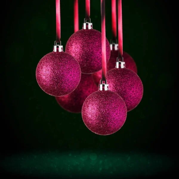 红色圣诞树饰物挂在复制空间 圣诞玻璃球或塑料球悬挂在抽象的深绿色背景之上 — 图库照片