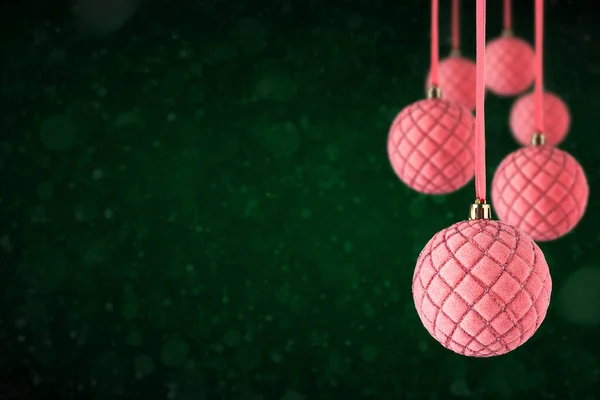 粉色圣诞树天鹅绒饰物挂在复制空间 圣诞玻璃球或塑料球悬挂在抽象的深绿色背景之上 — 图库照片