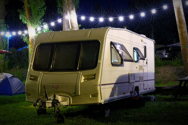 Travel Trailer Caravaning. RV Park Camping at Night. vacations, weekend, road trip, European mobile home on a camping site at night