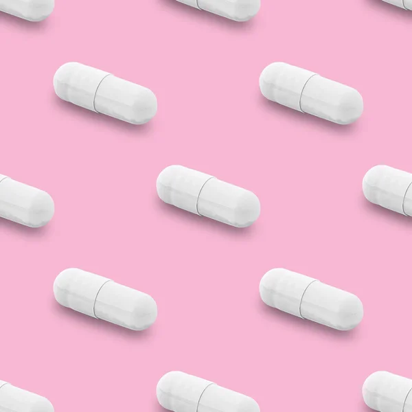 Gel capsule seamless pattern. White capsule shaped medicine. pharmacy concept. food supplement. Capsule pills pattern on a pink background