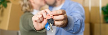 Couple showing keys to new apartment. real estate mortgage, loan concept. moving in new house. Young smiling couple holding their new house keys. first own apartment or house.