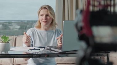 Beautiful middle aged blond woman making financial, investment or saving money content. Blogger creating content for social media. finance advisor management information